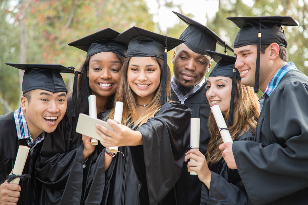 happy college graduates posing for selfie