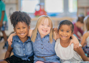 special needs girl with two friends, smiling